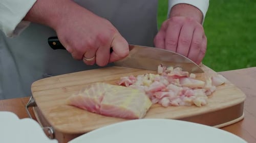 Adult Chef Dices Raw Fish on Wooden Board