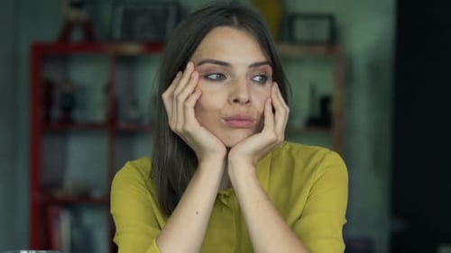 Sad businesswoman sits pensive and worried at her desk in her home office