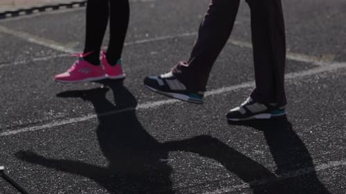 Las niñas hacen ejercicios de entrenamiento antes de la carrera, ejercicios de calentamiento muscular de las piernas