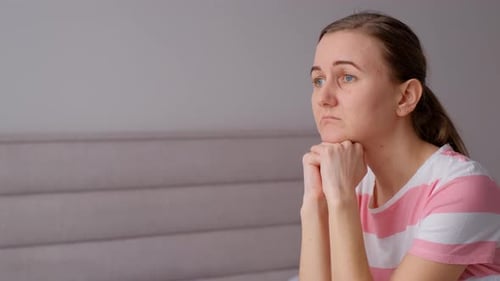 Sad Lonely Woman Sitting on Sofa Alone at Home Looking Disappointed Worried Thinking About Problems