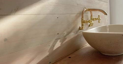 Close up of washbasin with running water in bathroom, slow motion