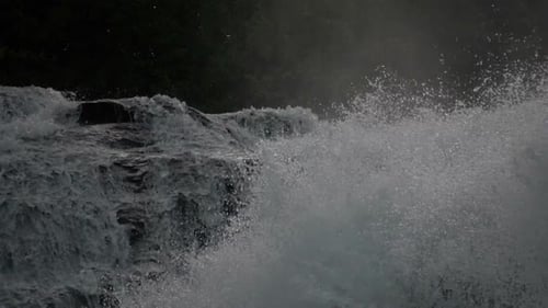 Powerful Waterfall Cascading Over Rocky Cliff