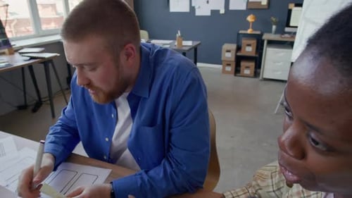 Black Female UI Designer Discussing App Layout with Male Colleagues at Office