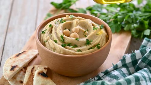 Close Up Hummus Being Drizzled with Olive Oil