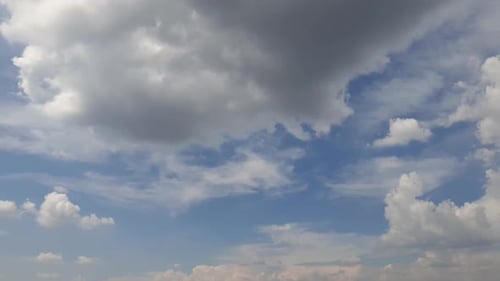 Blauer Sommerhimmel mit dichten, dichten Regenwolken, die sich über den Himmel ziehen. Schnelle Wolkenbildung und -bewegung