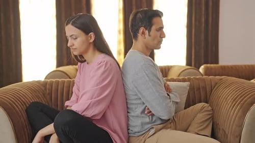 Pareja enojada sentada espalda con espalda y sin hablar