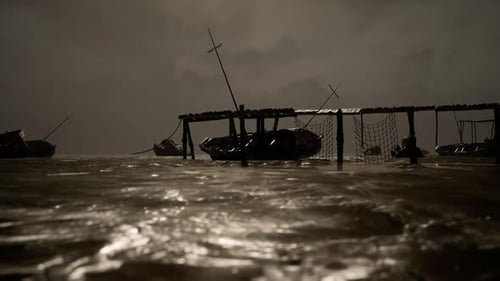 Fishing Boats Bobbing on Dark Waters Under Gloomy Sky at Night