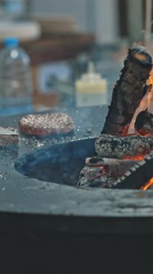 Wood Fire Burns under Meat Piece on Metal Surface