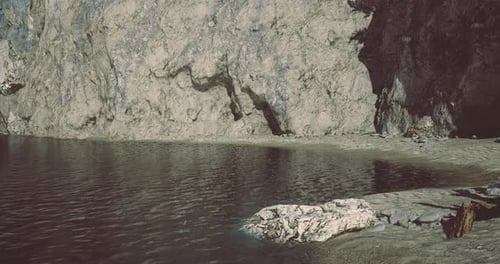 Rocky Shoreline with Tranquil Water at Golden Hour Creates Serene Atmosphere
