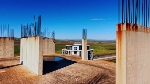 En la parte superior de la construcción inacabada se encuentran columnas y placas con barras metálicas que sobresalen.