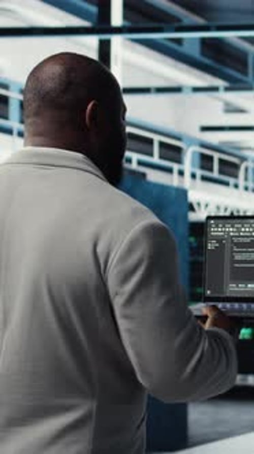 Vertical Video Data Center Computer Scientist Coding on Laptop Doing Software Updates