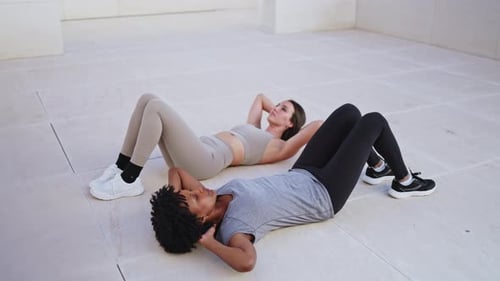 Young Adults Doing Sit Ups Outdoors
