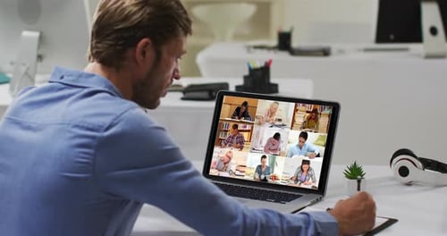 Man Attends Video Conference and Takes Notes