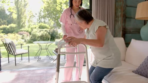 Helping senior asian woman with walker, nurse providing physical therapy at home