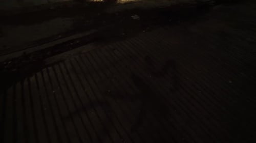 Interior pan reveal from bottom left to top right of an abandonded barn near an insane asylum, dark,