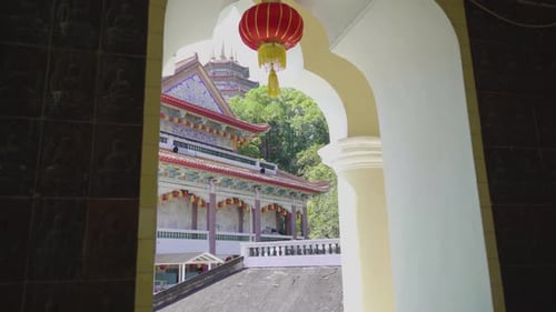 Dolly push through door with lantern reveals temple in Kek Lok Si