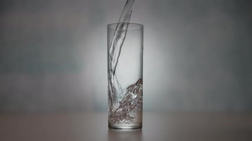 Water Being Poured Into Glass Cup
