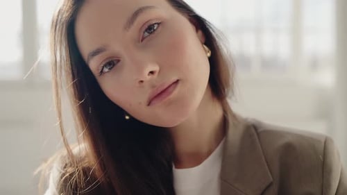 Beautiful Young Brunette Woman with White Shirt and a Brown Jacket at Studio
