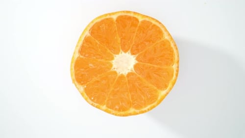 Una rodaja de naranja cortada por la mitad. 4K HDR