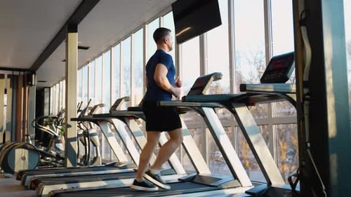 Man Running on Treadmill at Modern Gym