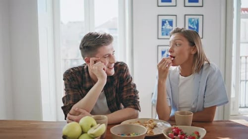 Young Adults Chatting Over Coffee and Strawberries