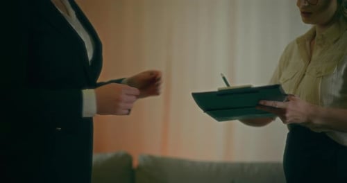 A Real Estate Agent Hands Over A Contract To A Client To Sign