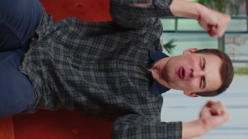 Excited Man Celebrates Success on the Couch