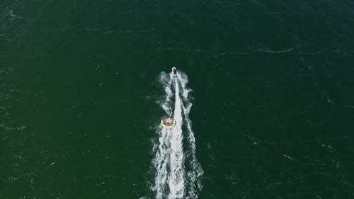 Jet ski pulling inflatable watercraft. Sea attraction for tourists on the beach. Sunny Beach
