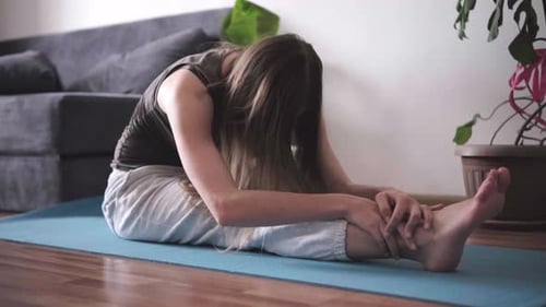 Woman Stretching on Yoga Mat in Living Room