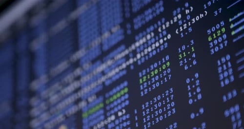 Rack focus and panning across a screen with digital coding and system logs