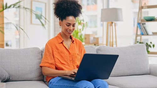 Woman Works on Laptop at Home on Couch