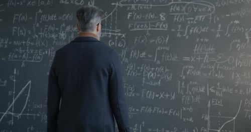 Back View of Man Professor Walking to Chalkboard Thinking and Underlining Formula Focused on Maths