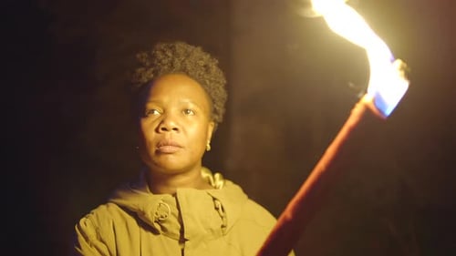 Woman Holding Burning Torch in the Dark Night
