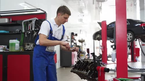 Auto Mechanic Assembles Engine in Workshop Professional Installs Crankshaft Bearings in Cylinder