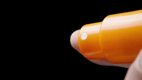 I Spritz Moisturizing Lotion from a Bottle, or Sunscreen Lotion. Skin Care Concept. Slow-Motion
