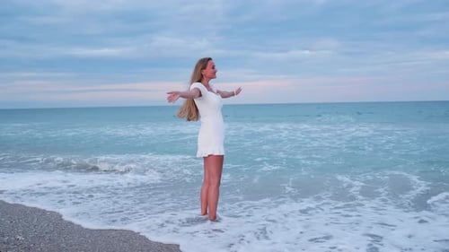 Blonde Woman Enjoying Ocean Waves During Beautiful Twilight Feeling of Freedom