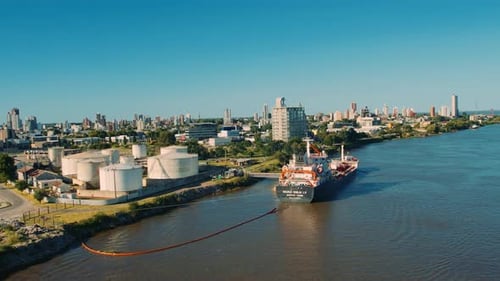 Aerial view over oil port and city. Where ship is loading fuel on the territory of large round stora