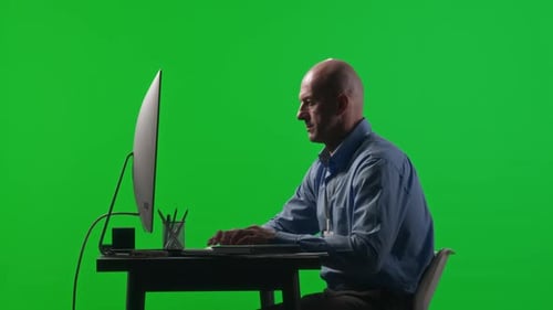 Businessman Using Computer at Office Workplace against Chroma Key Wall