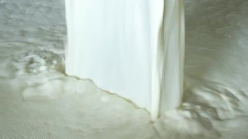 Worker pouring fresh milk into the milk tank for transport to dairy plant