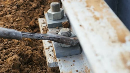 Funcionário conserta fixadores montando linha de alta tensão