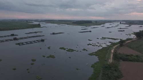 Aerial View Of A Lake With Structures And Cloudy Sky