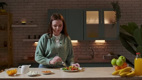 Woman Prepares Healthy Salad in Kitchen at Night