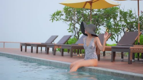 Woman Relaxing by Swimming Pool on Tropical Vacation