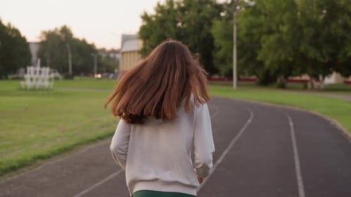 Woman Jogging Along Sport Stadium Track