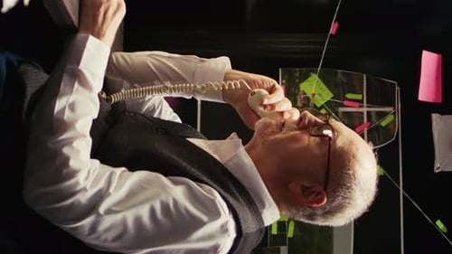 Adult Man on Telephone in Dark Office