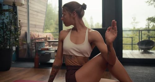 A Blonde Girl in a White Top Does Yoga and Does an Exercise to Stretch and Strengthen the Spine on a