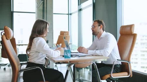 Business Professionals Make a Deal and Shake Hands Around a Conference Table in a Modern Office