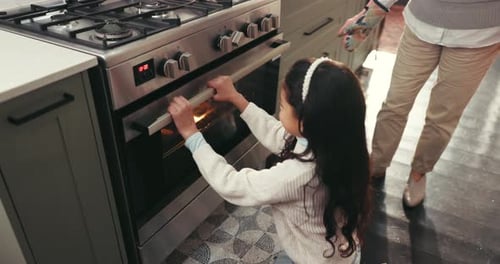 Girl opens oven with adult supervision at home