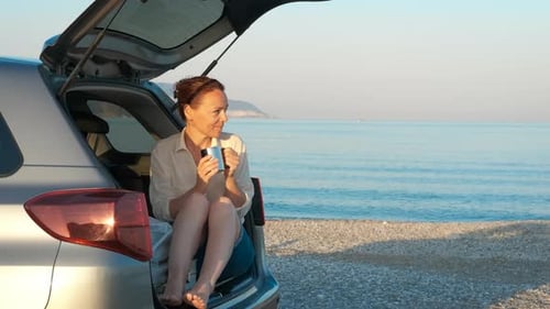 Joyful Traveler Woman Drink Coffee in Trunk