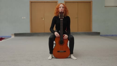 Woman with Guitar Sitting Posing in Room